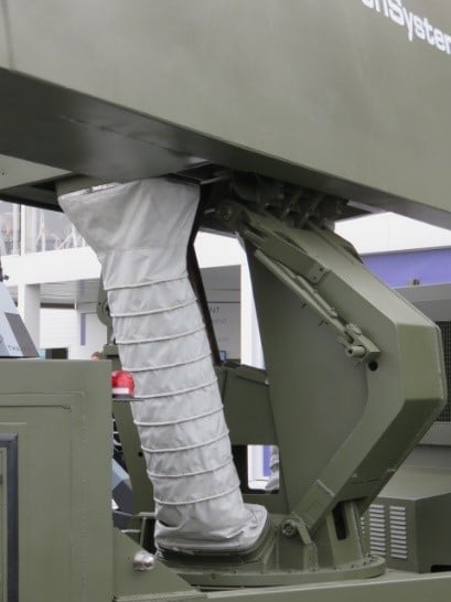 Défense-militaire-Gaine-ventilation-souple Une gaine souple grise sous un radar rotatif
