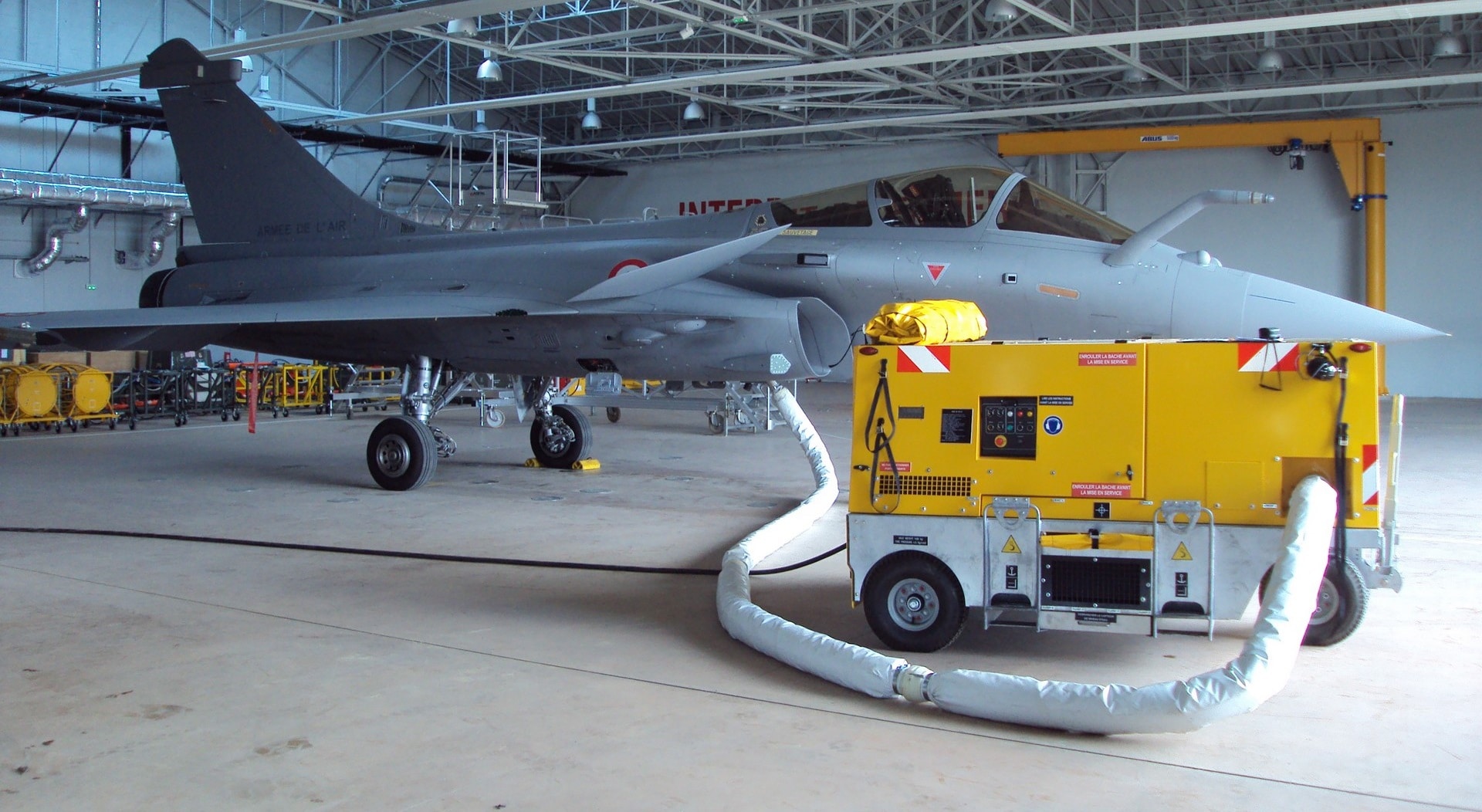 Un rafale avec un groupe climatisation jaune et une gaine souple blanche